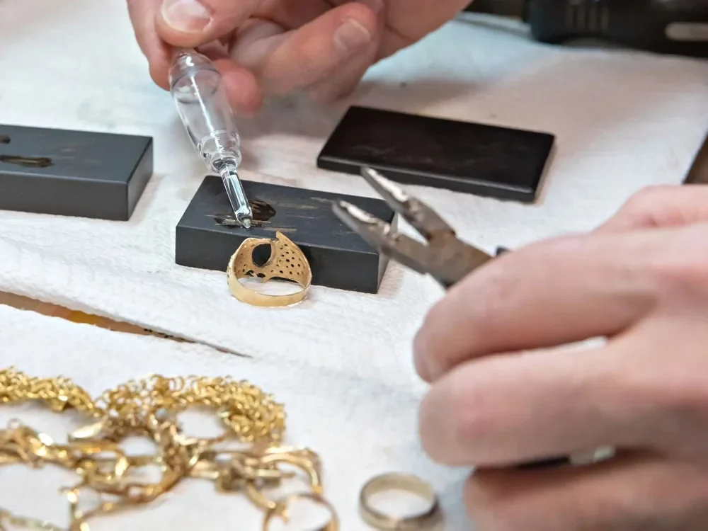 Gold jewellery being tested using an assay kit